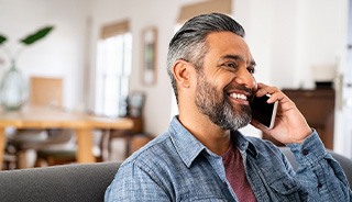 Man smiling while talking on phone