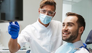 Dentist and patient reviewing information on screen