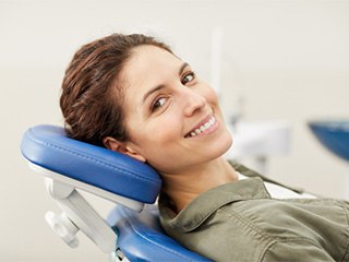 a smiling woman sitting in a dental chair