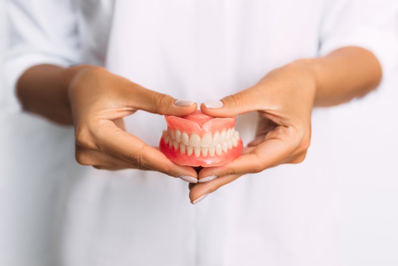 Lady presents dentures to viewer